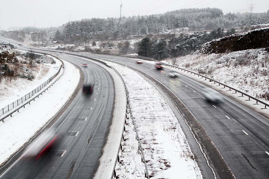 Snowy highway with moving cars