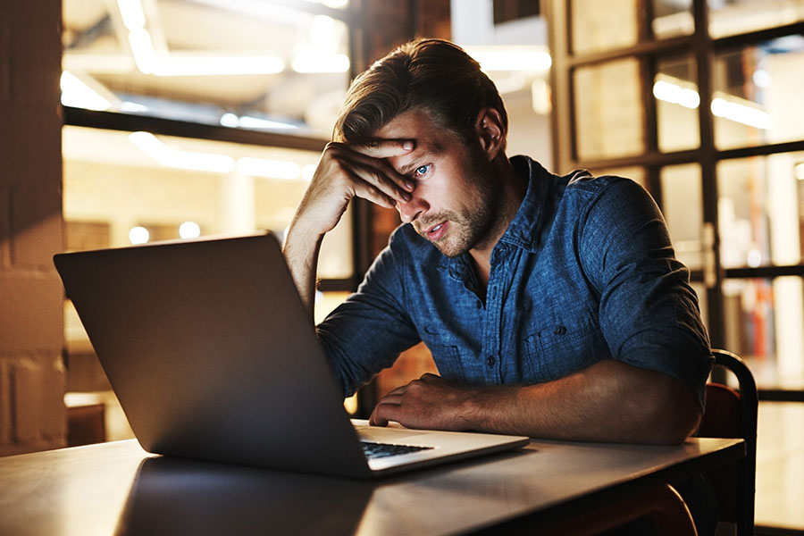 Stressed man working on laptop