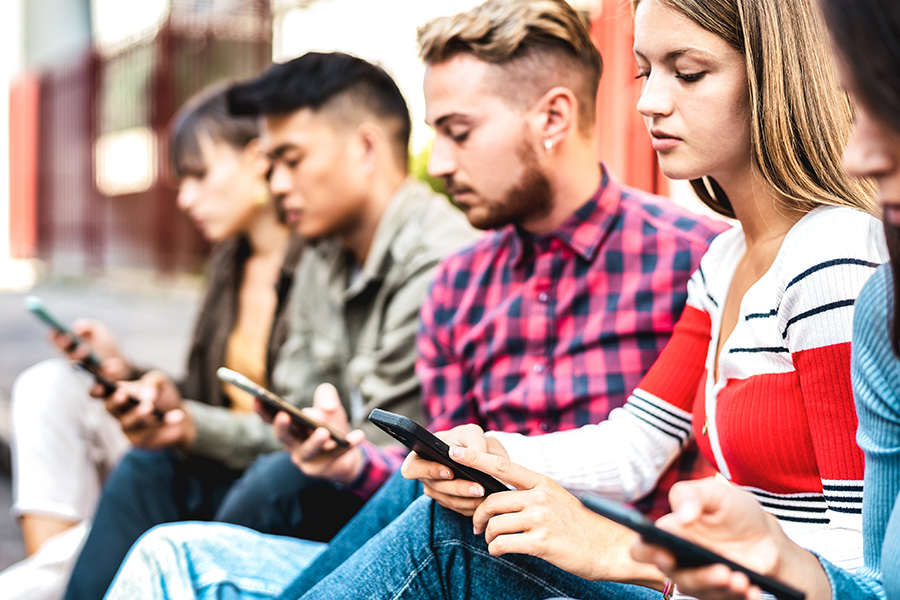 Young people using smartphones outdoors