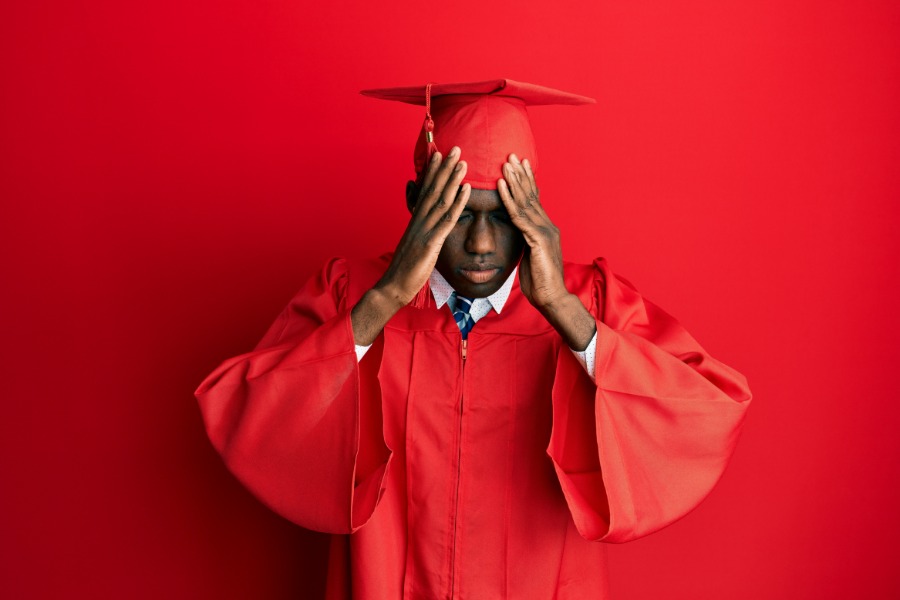 Stressed graduate in red gown