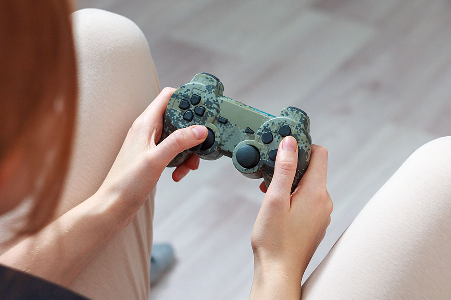 Hands holding camouflage game controller