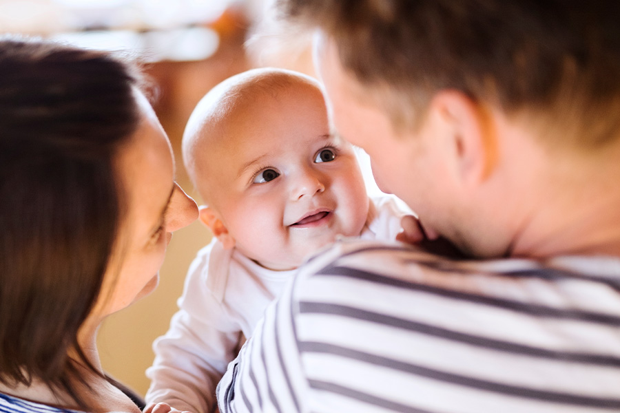 Smiling baby with parents cuddling